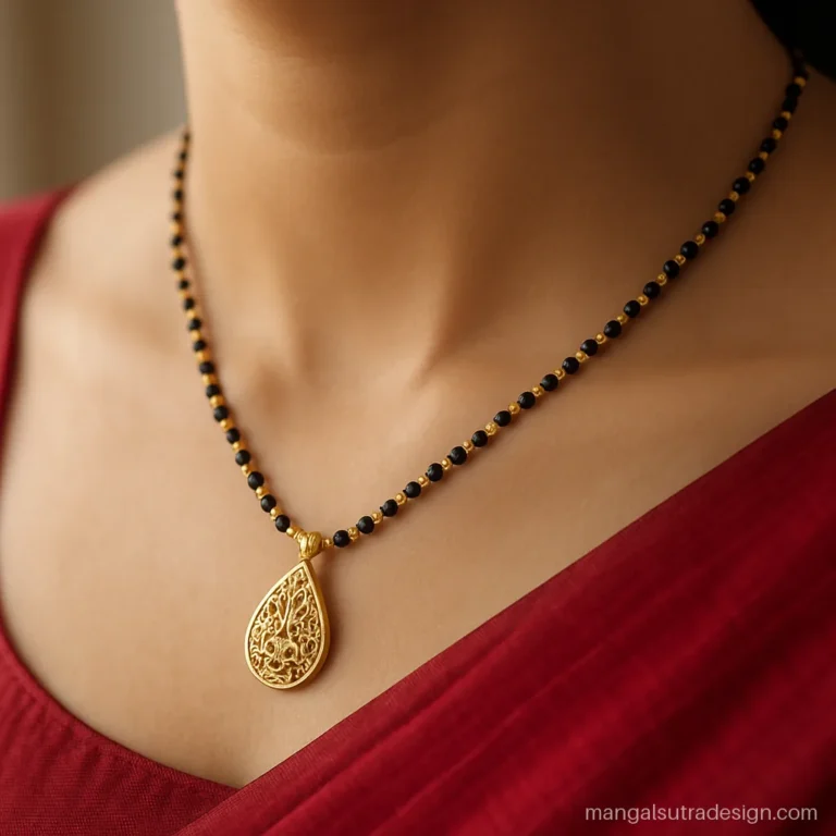 Women's gold mangalsutra design with filigree teardrop pendant and gold mani beads