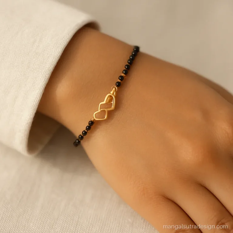 New mangalsutra bracelet on a wrist with twin gold hearts and black beads