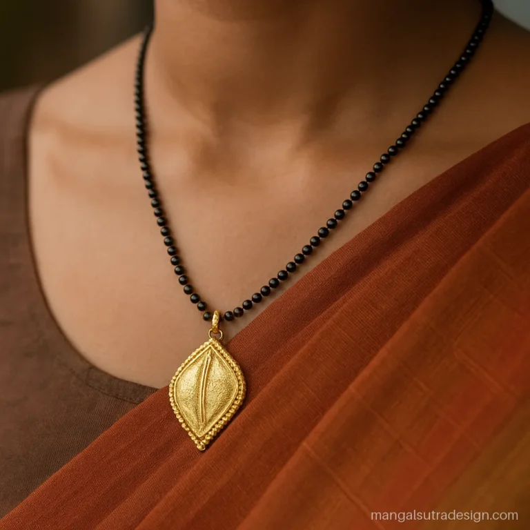 Long gold Hindu mangalsutra design with a leaf drop pendant and gold granule work