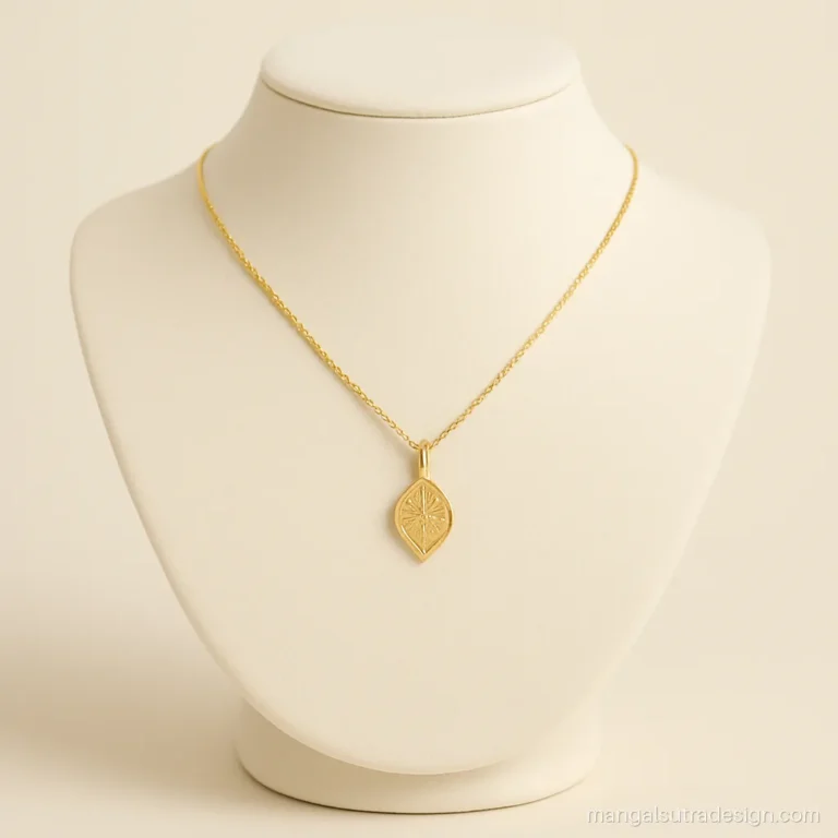Small leaf shaped gold minnu pendant on a thin gold chain from Kerala