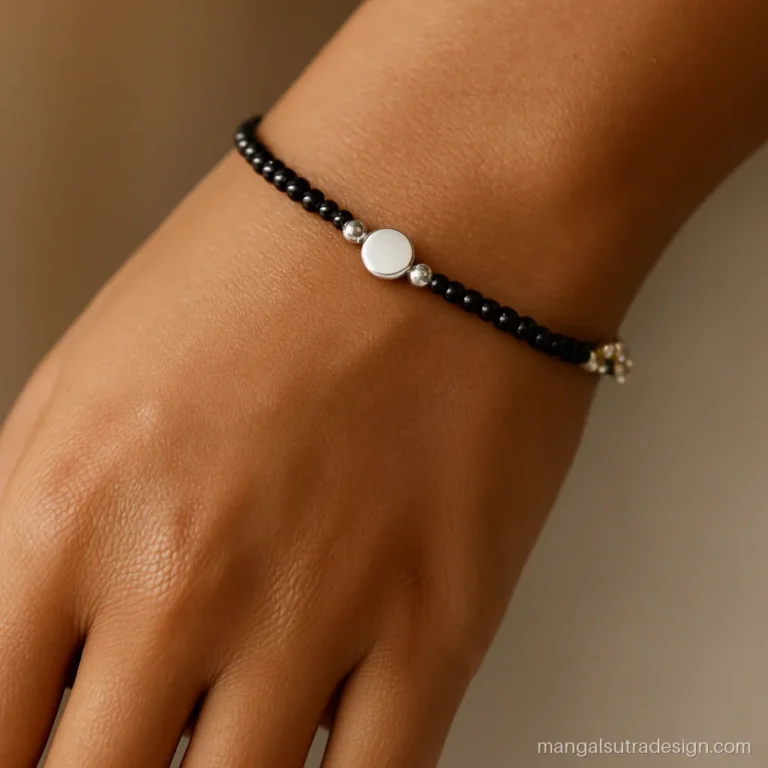 Silver mangalsutra bracelet with black beads and a small round silver charm on the wrist