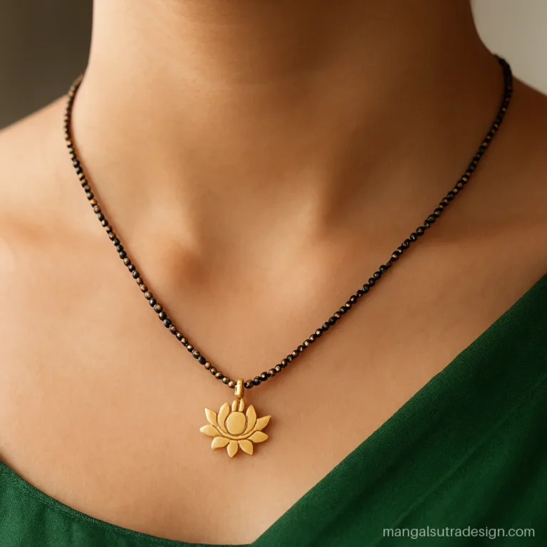 Short gold mangalsutra with a small lotus shaped vati worn with a silk saree blouse